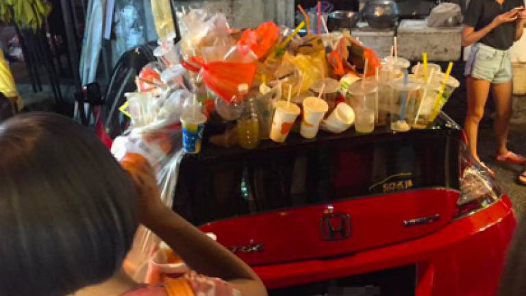 Malaysians turn parked car into trash can