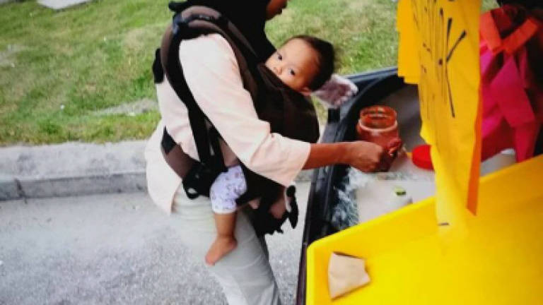 Woman sells nasi lemak from car boot while caring for three kids