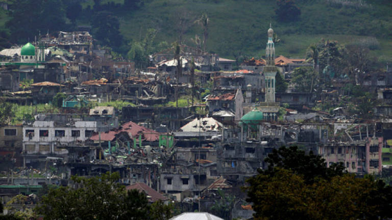 Philippine army says taking fire from women, children in Marawi battle