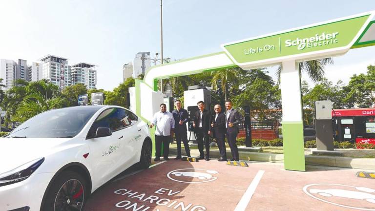 From feft: Bukit Gasing assemblyman Rajiv Rishyakaran, Quah, Wong, Tan and Schneider Electric Malaysia residential and general distribution VP vice-president Francis Heng at the site of the new EV charging station.