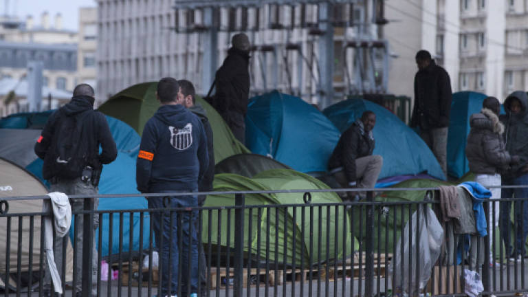 French police clear migrant camps in Paris, Calais