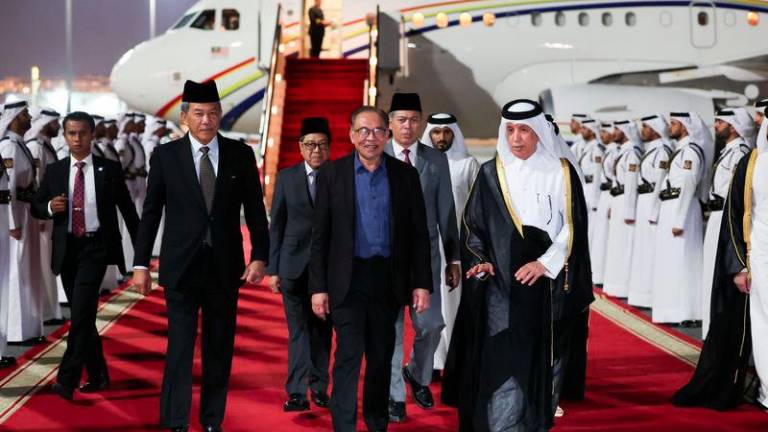 Prime Minister Datuk Seri Anwar Ibrahim disembarks from his plane as he arrives at the Doha International Airport on Sunday night. - fotoBERNAMA