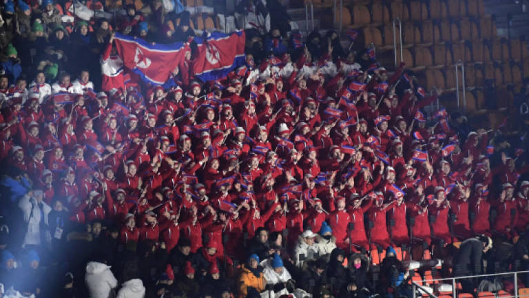Life's a beach as North Korea cheerleaders mobbed by media