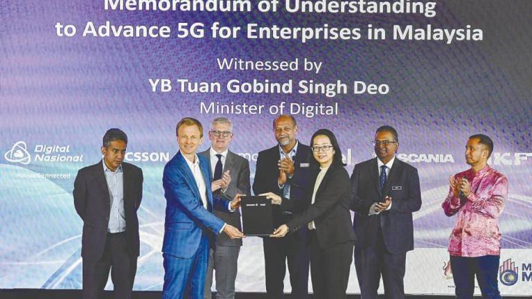 Gobind (centre) and Ekholm (third from left) witnessing the exchange of documents after the signing of a memorandum of understanding between DNB and Ericsson with enterprise partners at DNB's headquarters in Kuala Lumour. Also present are Ahmad Zaki (left) and DNB chief operating officer Nasution Mohamed (right).– Bernamapic