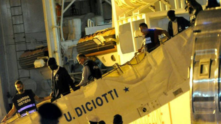 Dozens of migrants disembark from coastguard ship in Italy