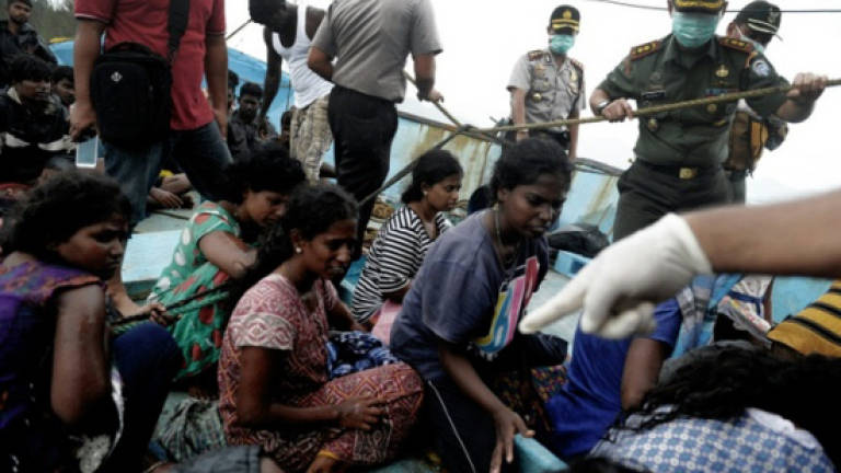 Warning shot fired in Indonesian migrant boat stand-off