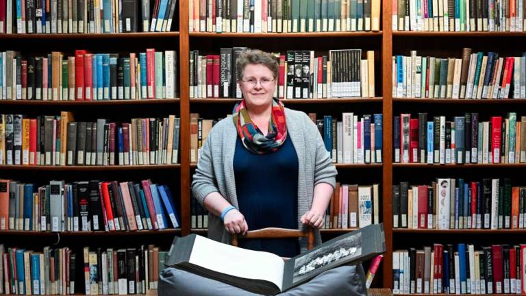 College Archivist Frieda Midgley poses for a portrait in the library at Newnham College, part of the University of Cambridge, on March 21, 2024, in Cambridge, eastern England. - AFPPIX