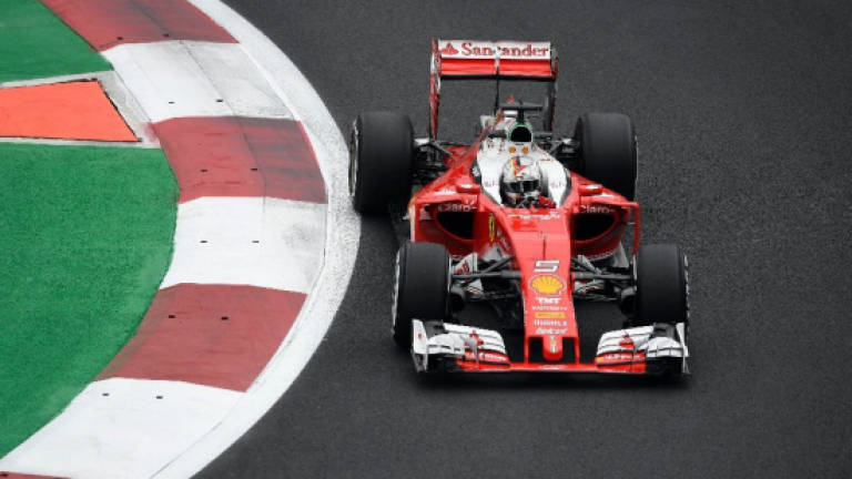 Vettel hands Ferrari boost, Hamilton edges Rosberg