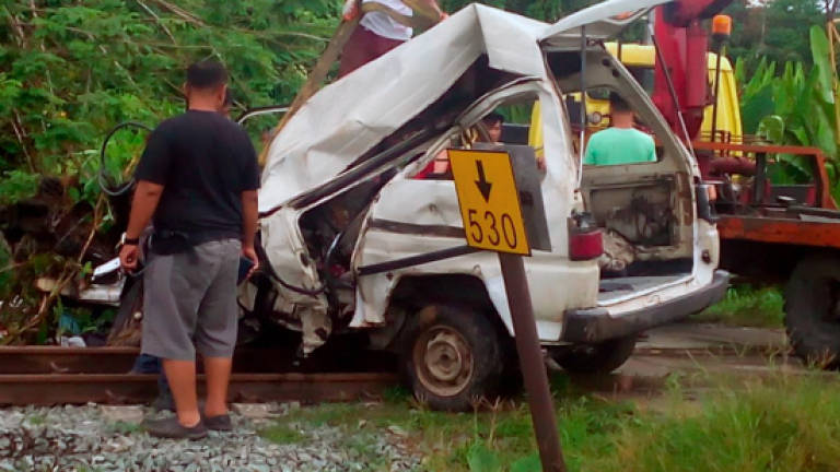 Train crashes into van, killing three, injuring four