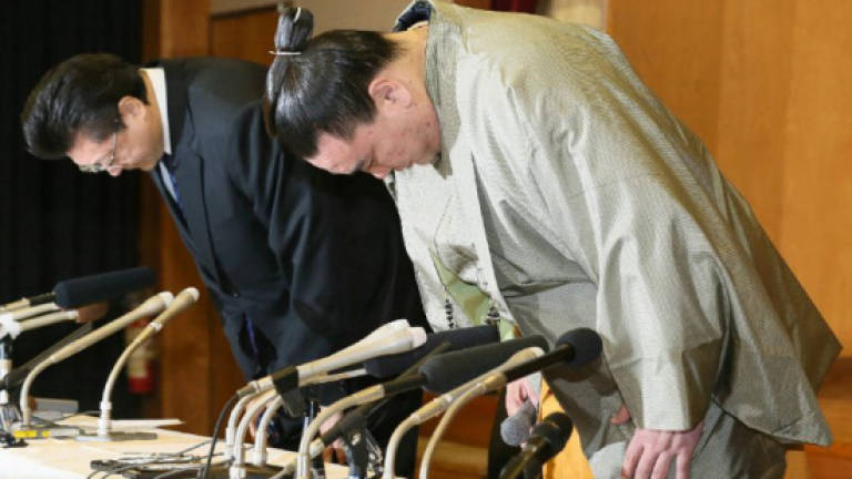 Tearful sumo champion steps down after brutal attack on rival