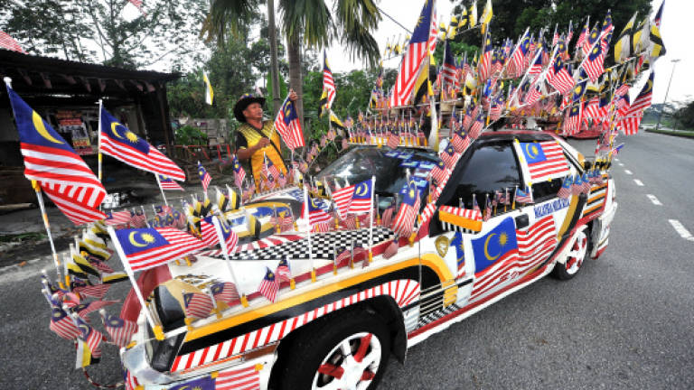 Man decorates car with 100 Jalur Gemilang