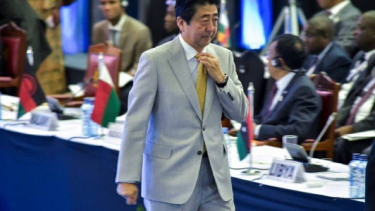 Japan's Abe in Russia to warm ties with Putin