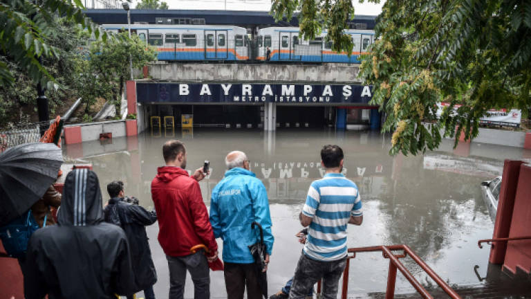People swim in streets of flooded Istanbul, heavy rain briefly shuts Bosphorus oil routes