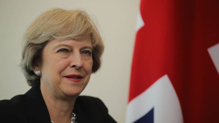 May calls for tougher stance on migrants