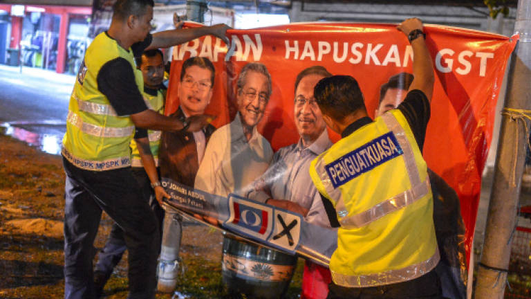 EC officers remove images of Tun M in midnight operation