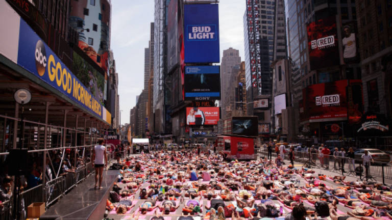 Thousands of yoga fans hit Times Square to welcome summer