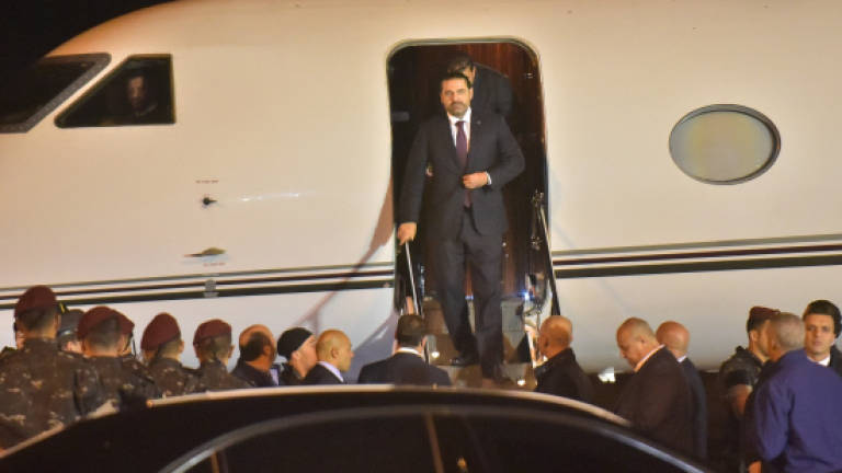 Hariri says resignation on hold, pledges to stay in Lebanon