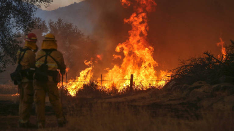 California fire destroys 80 buildings, closes highways
