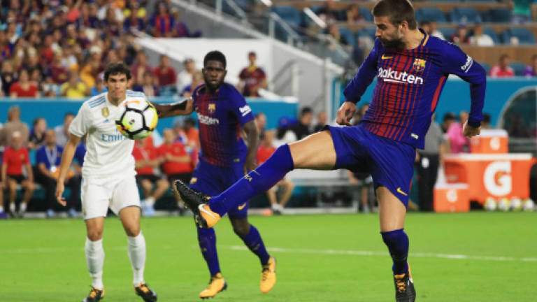 Pique lifts Barcelona as El Clasico lives up to hype