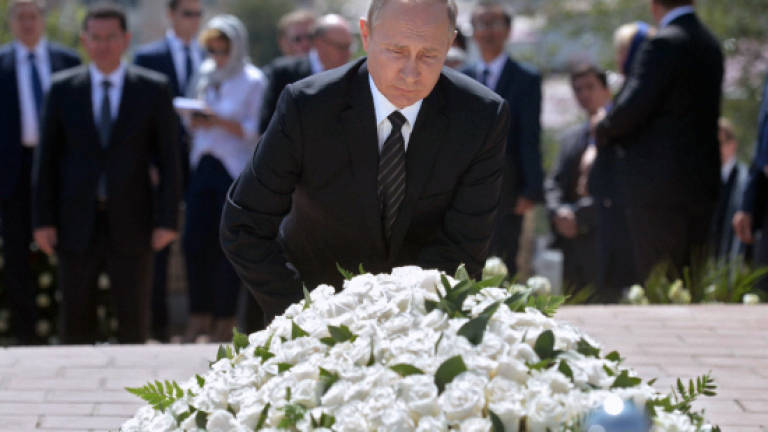 Putin lays flowers at Uzbek strongman's grave