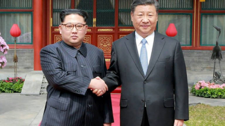 N. Korea's Kim shows unity with China's Xi in first foreign trip