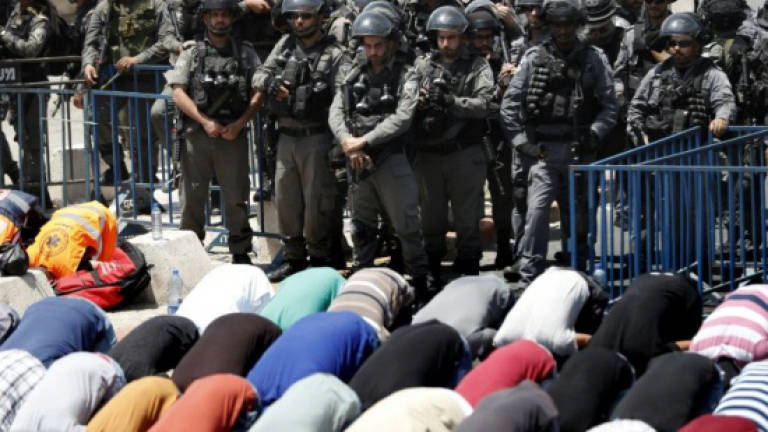 Palestinians pray outside holy site after Israeli restrictions