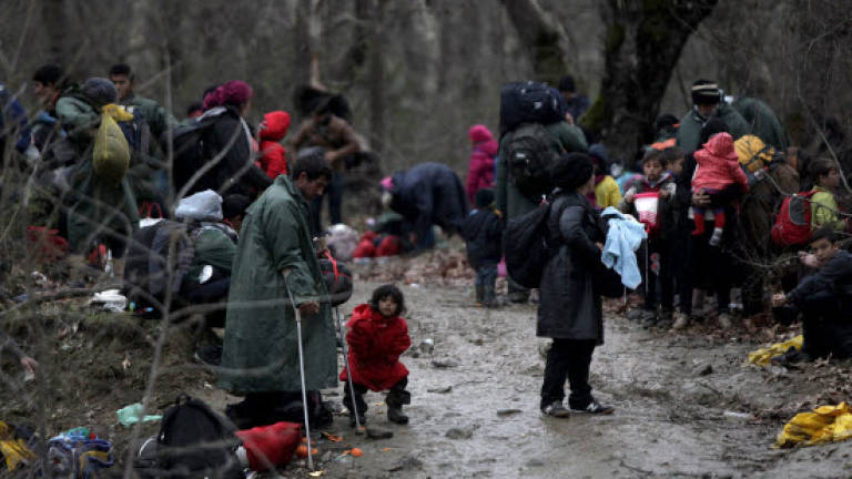 Hundreds of migrants march out of Greek camp, cross to Macedonia