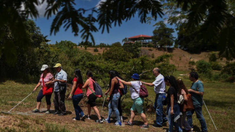 Blind visitors in Colombia try salsa, paragliding