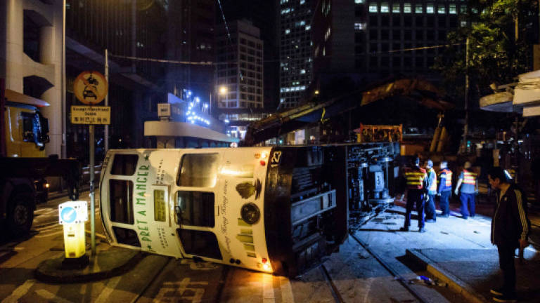 Driver arrested after HK tram flips over, injuring 14