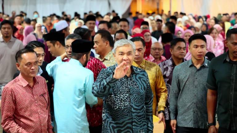 Timbalan Perdana Menteri yang Presiden Umno Datuk Seri Dr Ahmad Zahid Hamidi (tengah) melambaikan tangan kepada tetamu sewaktu menghadiri Majlis Perasmian Persidangan Cawangan-Cawangan Umno Bahagian dan Santapan Hari Raya Aidilfitri Umno Bahagian Putatan - fotoBERNAMA