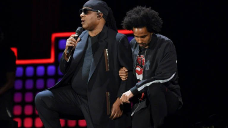 Stevie Wonder kneels as he leads anti-poverty concert
