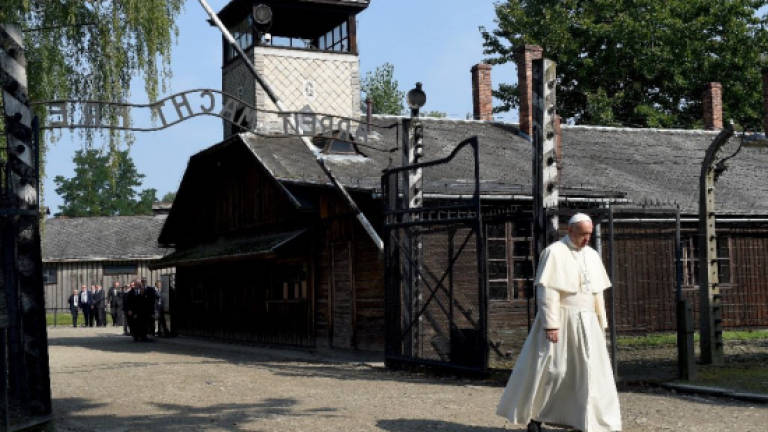 Pope Francis walks alone through horrors of Auschwitz
