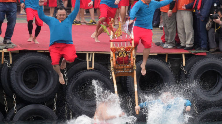 Worshippers throw themselves into Taiwan harbour for good luck