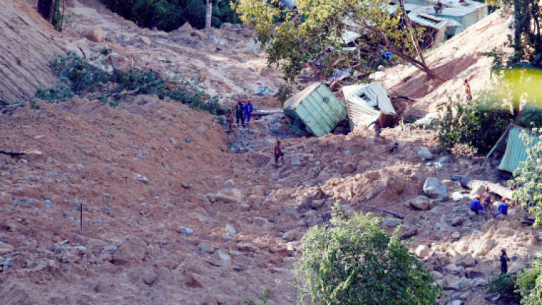 Father pulls out son's body from landslide