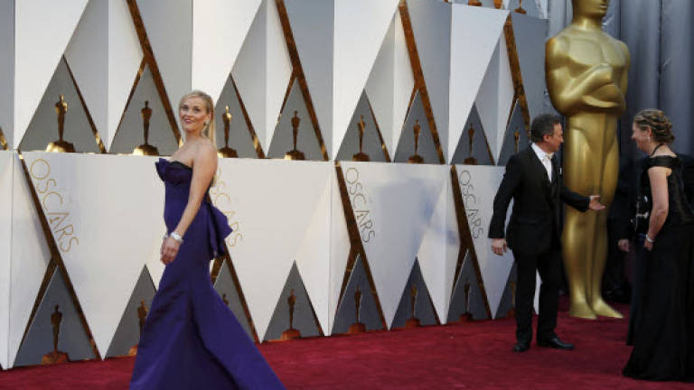 Oscars red carpet underway, suspense over Chris Rock monologue