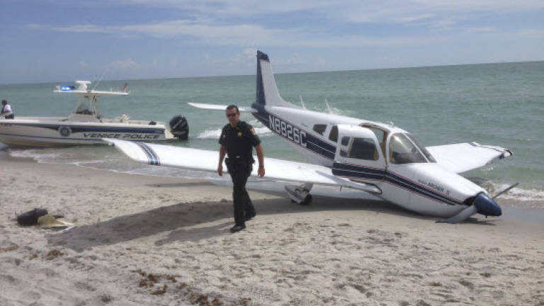 Plane crash-lands on US beach, killing father