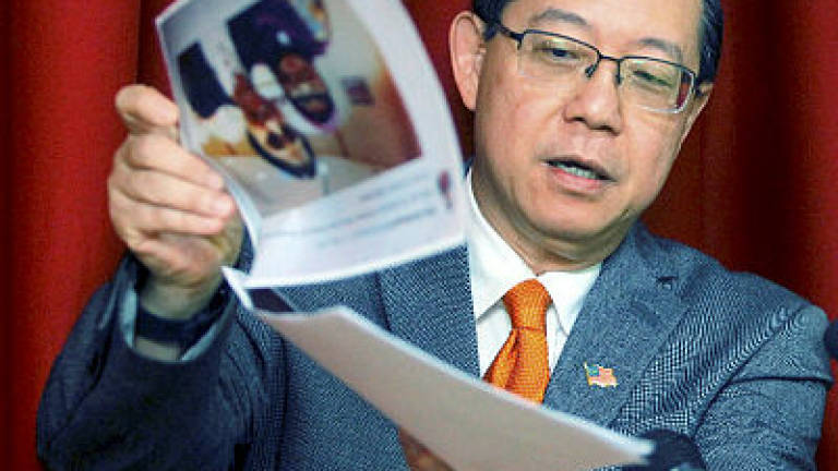 Guan Eng shows photographs of wife of project 'fixer' allegedly pictured with BN leaders