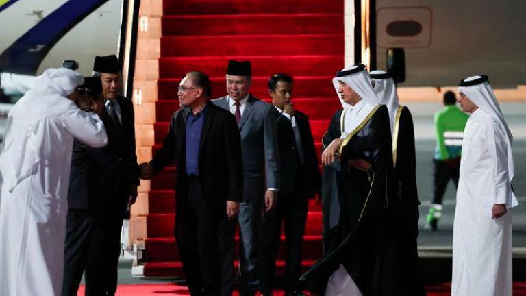 Prime Minister Datuk Seri Anwar Ibrahim disembarks from his plane as he arrives at the Doha International Airport on Sunday night. - fotoBERNAMA