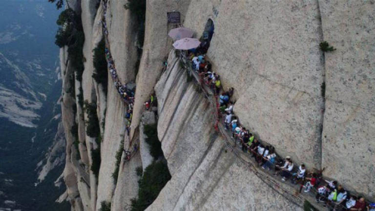 (Video) Death-defying cliffside plank walk jam-packed with tourists