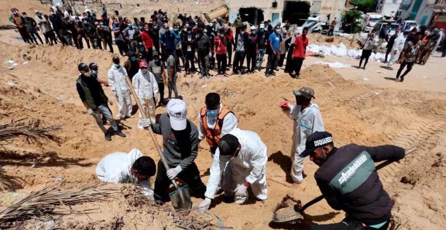 People work to move into a cemetery bodies of Palestinians killed during Israel’s military offensive and buried at Nasser hospital, amid the ongoing conflict between Israel and the Palestinian Islamist group Hamas, in Khan Younis in the southern Gaza Strip, April 21, 2024/REUTERSPix