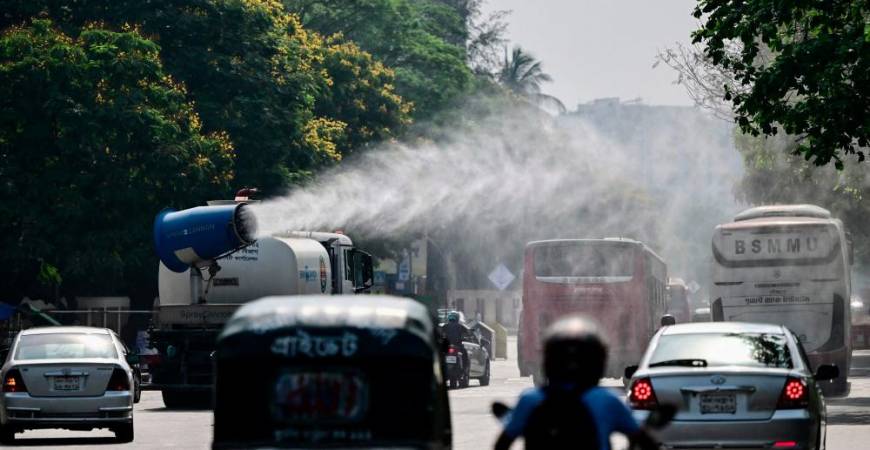 A vehicle of the Dhaka North City Corporation (DNCC) sprays water along a busy road to lower the temperature amidst a heatwave in Dhaka on April 27, 2024. - AFPPIX