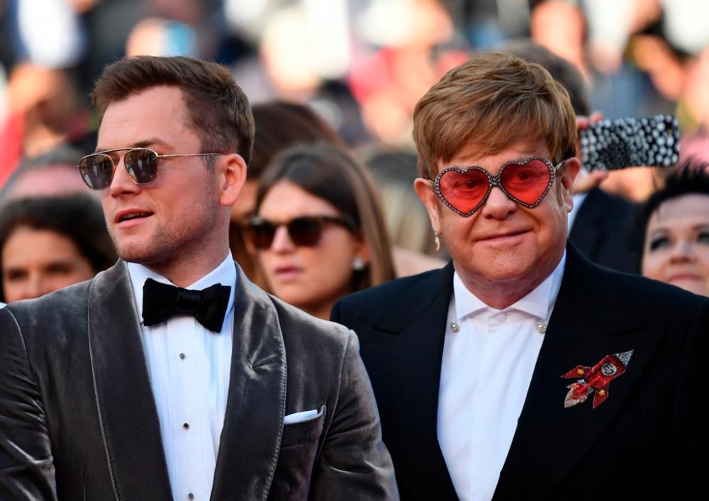 British singer-songwriter Elton John (R) and British actor Taron Egerton (L) arrive for the screening of the film “Rocketman” at the 72nd edition of the Cannes Film Festival in Cannes, France, on May 16, 2019. © Alberto PIZZOLI / AFP