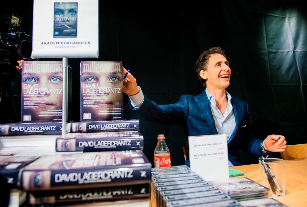 David Lagercrantz, author of the final three novels in the Millennium series, originally by Stieg Larsson, signs copies of “The Girl in the Spider’s Web” at a bookstore in Stockholm. Lagercrantz was commissioned to continue the saga after Larsson’s death. © JONATHAN NACKSTRAND / AFP
