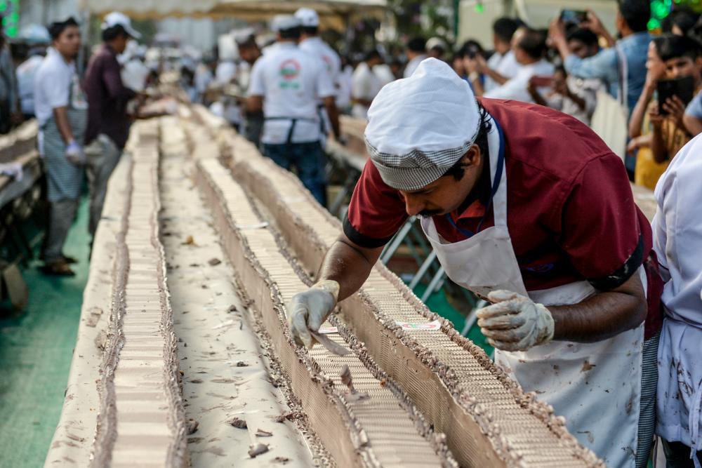 A baker prepares an approximately 6.5-km long cake in an attempt aim to break the Guinness World Record for the longest cake, in Thrissur in the south Indian state of Kerala on January 15, 2020. © Arun SANKAR / AFP