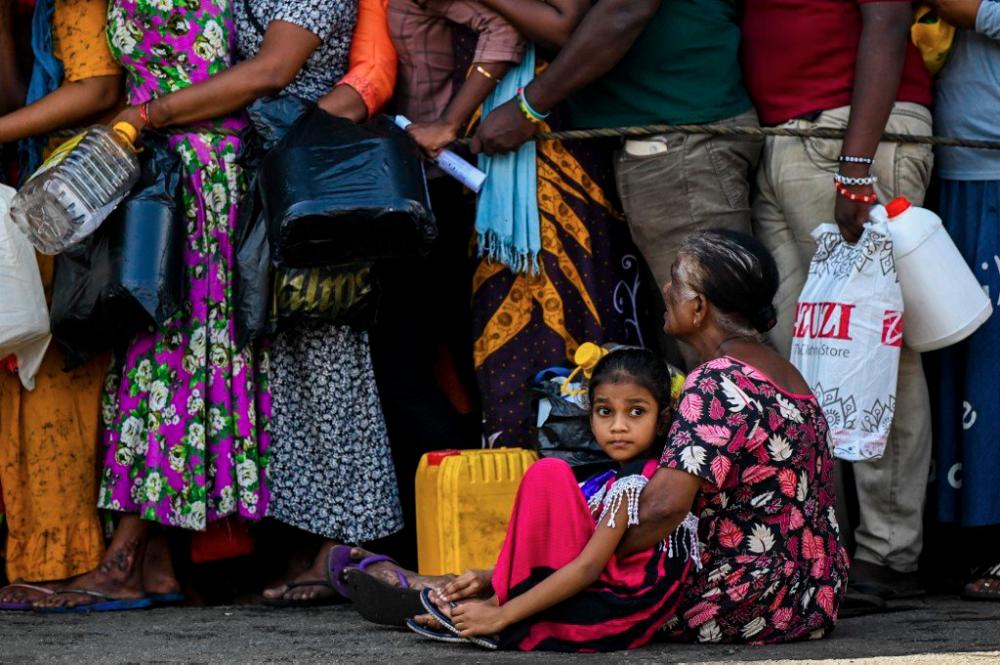 People queue up to buy kerosene for domestic use at a supply station in Colombo on May 26. AFPPIX