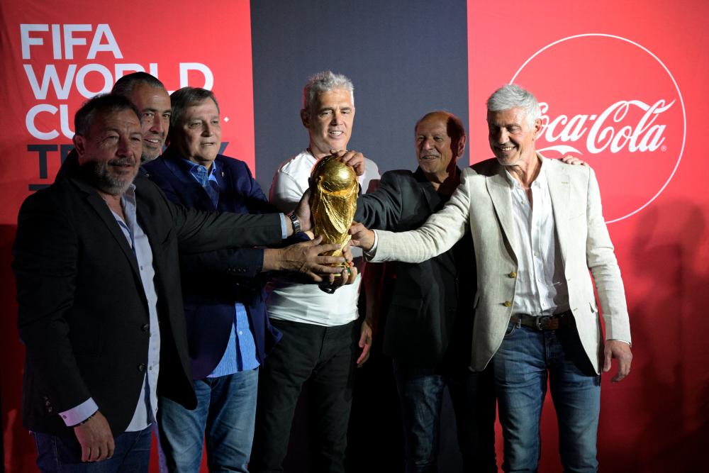 $!FROM LEFT: Argentina’s 1978 and 1986 World Cup Champions Carlos Tapia, Sergio Batista, Daniel Bertoni, Alberto Tarantini Omar Larossa and Ricardo Giusti hold the FIFA World Cup trophy in Ezeiza, Buenos Aires during the world tour ahead of the FIFA World Cup Qatar 2022. – AFPPIX