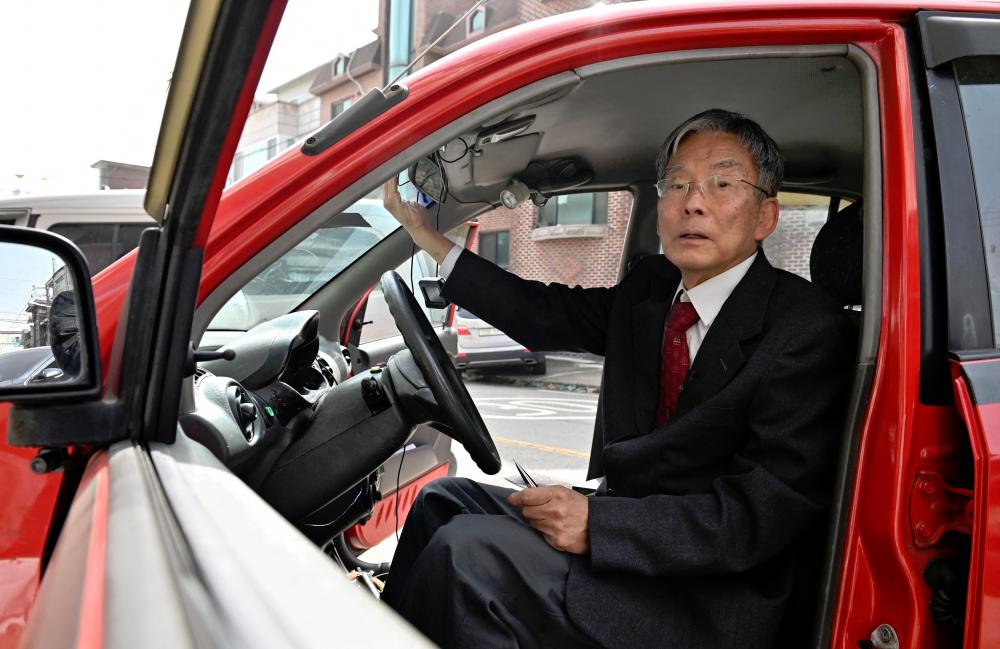 Professor Han sitting in his 21-year-old self-driving car in front of his office in Yongin, south of Seoul.