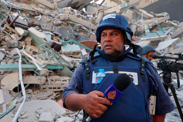 Al-Jazeera journalists stand next to the rubble of Jala Tower, which was housing international press offices, following an Israeli airstrike in the Gaza Strip on May 15, 2021. — AFP