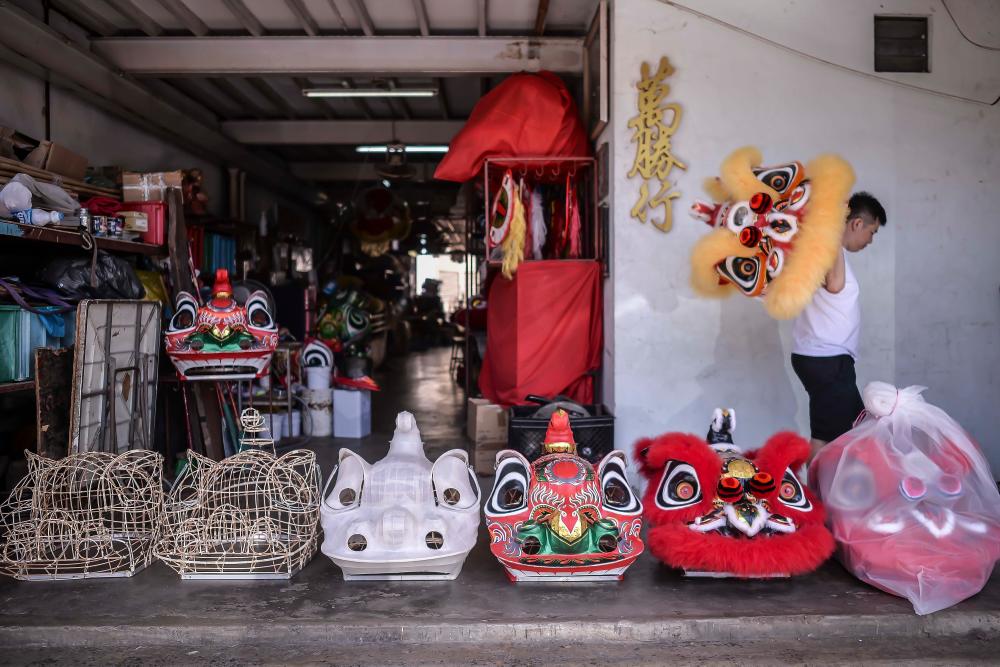 Wong walk past the process of making the lion head, from the bamboo frame to the complete lion dance head which is completely wrapped in plastic cover. ADIB RAWI YAHYA/THESUN