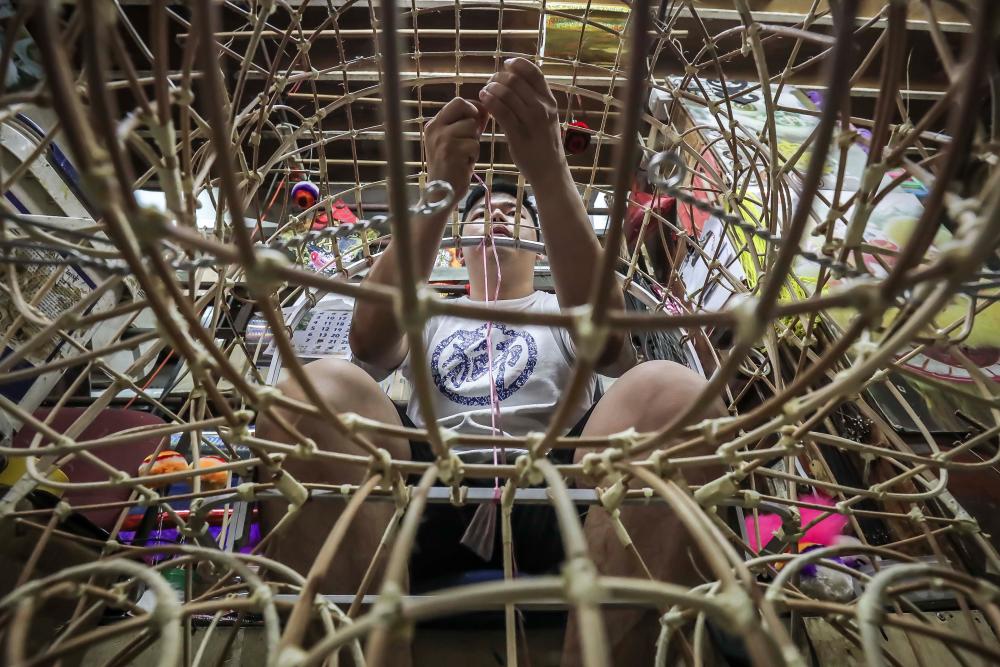 $!Wong then shapes the rattan by hand and secure with adhesive tape to make the lion head frame commonly used for lion dance. ADIB RAWI YAHYA/THESUN